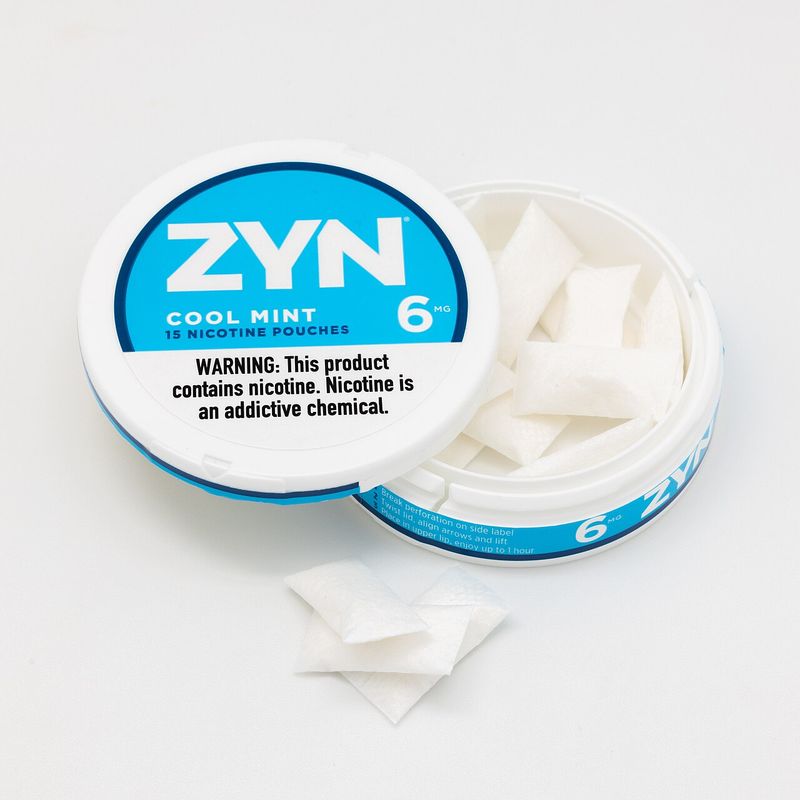 Open can of ZYN Cool Mint 6mg nicotine pouches with loose pouches beside it